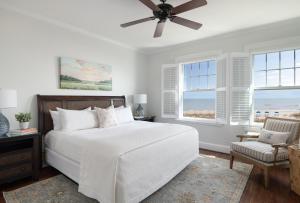 a bedroom with a bed and a fan and windows at Elizabeth Pointe Lodge in Fernandina Beach