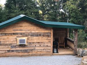 a log cabin with a green roof at Harper Tree Top in Rising Fawn