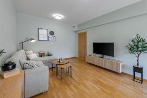 River Apartment في دوبروفنيك: غرفة معيشة مع أريكة وتلفزيون بشاشة مسطحة