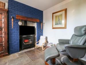 a living room with a couch and a fire place at Woodpit Cottage in Nottingham
