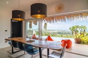a dining room with a table and chairs and a large window at Villa Samurai Panoramic Sea & Jungle Views in Bophut 