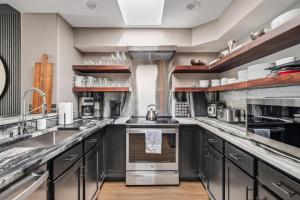 una cucina con armadietti grigi ed elettrodomestici in acciaio inossidabile di 3 Bed 2 Bath Central Upscale Home near BC, Vail ad Avon