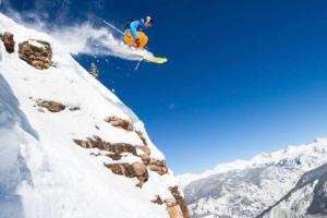 a person jumping off of a snow covered mountain on skis at Sunny Vail Mountainside Getaway Amazing Location in Vail