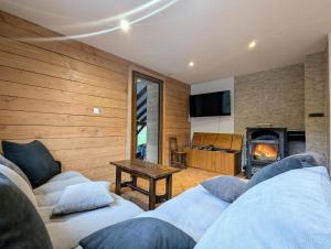 ein Wohnzimmer mit zwei Sofas und einem Kamin in der Unterkunft Hêtre pourpre in Ventron