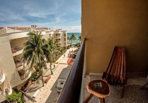 balcón con vistas a la playa y a los edificios en Beachfront Chic at El Faro Resort, en Playa del Carmen