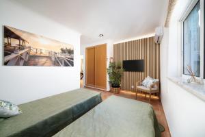 a bedroom with a bed and a television in a room at Casa Paraiso - stylish gateway in Carvoeiro