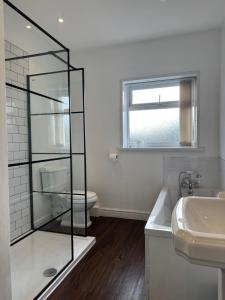 Un baño con ducha de cristal y lavabo. en Spacious Victorian Birkdale Apartment with Garden, en Southport 11 fotos más