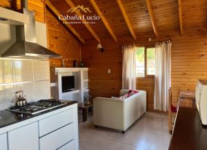 a kitchen with a stove and a couch in a room at Cabaña Lucio in Esquel