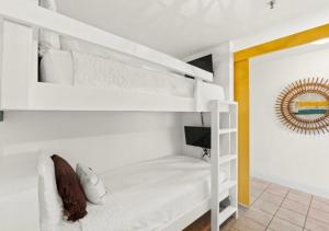 a white bunk bed in a white room with a television at BeachFrnt 2 Hottub 5 Pools Jet Ski in Panama City Beach +19 photos
