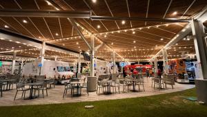 a large pavilion with tables and chairs and vehicles at Residencias Cityzen cerca del Aeropuerto in Echeverría