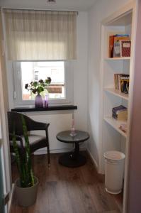 een kamer met een stoel, een tafel en een raam bij Gästehaus Praliné in Bremm