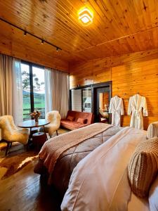 a bedroom with a bed and a living room at Flor da serra in Urubici