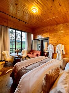 a bedroom with two beds and a table in a room at Flor da serra in Urubici