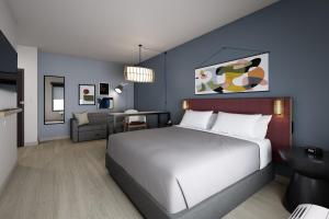 a bedroom with a large white bed and a table at Atwell Suites Corpus Christi Southeast by IHG in Corpus Christi