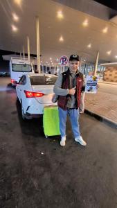 a man standing in a parking lot with his luggage at Paradise Hill in Hurghada