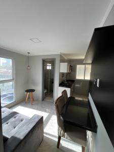 ein Wohnzimmer mit Couch und Küche in der Unterkunft Flat de alto padrão ar condicionado piscina e academia in Campina Grande