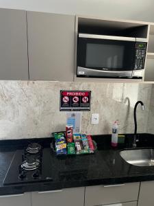 eine Küchentheke mit einer Mikrowelle über einem Herd in der Unterkunft Flat de alto padrão ar condicionado piscina e academia in Campina Grande + 1 Foto