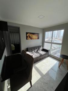 ein Wohnzimmer mit Couch und großem Fenster in der Unterkunft Flat de alto padrão ar condicionado piscina e academia in Campina Grande