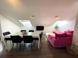 a living room with a pink couch and a table at Apartments Monika & Breakfast Baskets 145 in Punat