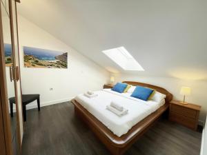 a bedroom with a large bed with blue pillows at Apartments Monika & Breakfast Baskets 145 in Punat +47 photos