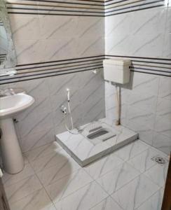 een witte badkamer met toilet en wastafel bij Karachi Motel Guest House in Karachi +27 foto's