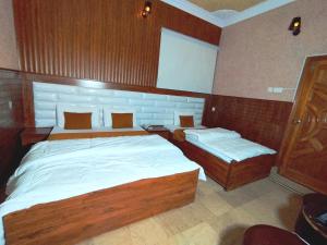 een slaapkamer met een groot bed en 2 aparte bedden bij Karachi Motel Guest House in Karachi