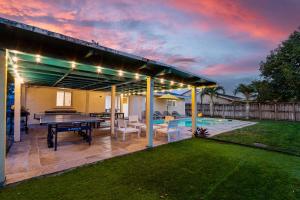 a patio with a ping pong table and a pool at 4BR with Private Pool and Game Room - Prime Location in Fort Lauderdale