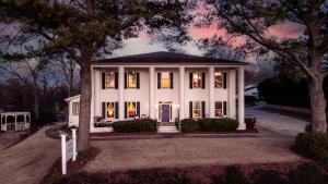 a white house with a tree in front of it at Stone Mountain Manor in Stone Mountain