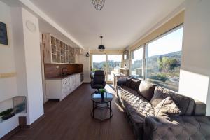 ein Wohnzimmer mit Couch und großem Fenster in der Unterkunft Majestic Apartment in Tivat