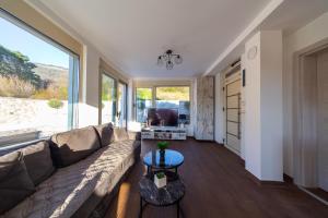 ein Wohnzimmer mit Couch und großem Fenster in der Unterkunft Majestic Apartment in Tivat + 27 Fotos