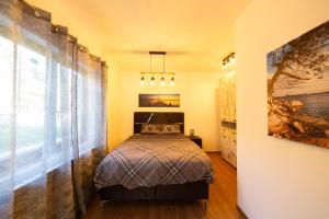 ein Schlafzimmer mit einem Bett und einem großen Fenster in der Unterkunft Majestic Apartment in Tivat