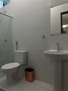 a bathroom with a toilet and a sink at Suites Brejauva in Ubatuba