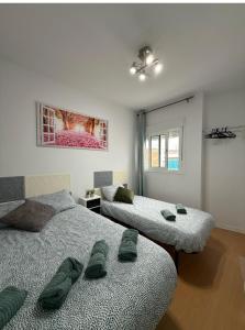 una camera con due letti e un dipinto sul muro di HABITACIÓN triple con baño compartido LOVELY SEVILLA a Camas Altre 9 foto