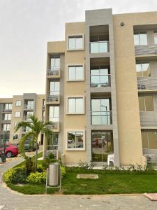 un immeuble d'appartements avec un palmier en face de celui-ci dans l'établissement Apartamento Cartagena Serena del Mar - Capriella, à Manzanillo del Mar
