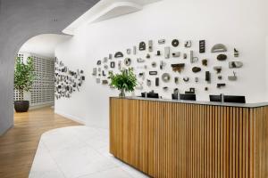 旧金山Timbri Hotel San Francisco, Curio Collection by Hilton的大堂设有木柜台和挂有照片的墙壁