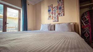 a bedroom with a large bed with a large window at Hotel Bankir Khiva in Khiva