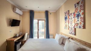 a hotel room with a bed and a window at Hotel Bankir Khiva in Khiva