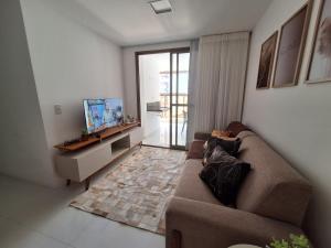 a living room with a couch and a flat screen tv at Apartamento luxo, pertinho do Mar e lazer maravilhoso in Vila Velha