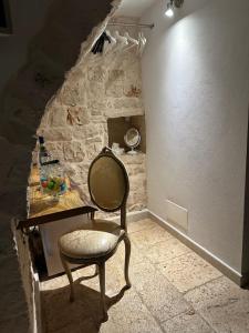 ein Stuhl in einem Raum mit einer Steinwand in der Unterkunft Murantiche in Putignano + 8 Fotos