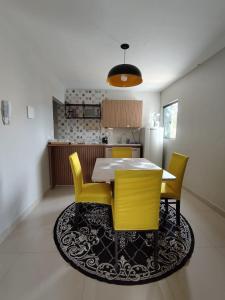 una cucina con tavolo da pranzo e sedie gialle di Apartamento recanto paz a Teresina