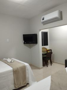 Camera bianca con letto e TV a parete di Apartamento recanto paz a Teresina