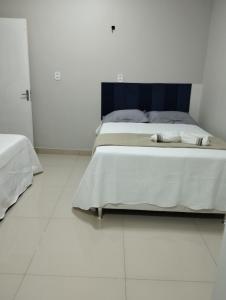a white bedroom with two beds in it at Apartamento recanto paz in Teresina