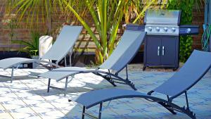 a group of chairs sitting on a patio with a grill at Villa Serenity in Saint-François