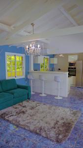 a living room with a green couch and a kitchen at Villa Serenity in Saint-François
