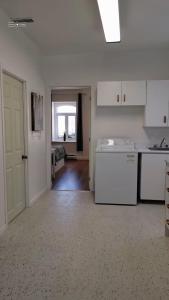Una cocina con gabinetes blancos y un lavavajillas blanco. en Cozy Suite #3 in the Heart of DT Quebec with QB, en Quebec