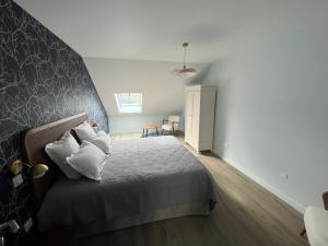 a bedroom with a bed with white pillows at Moulin Lèves-Chartres Au fil de l eau in Lèves