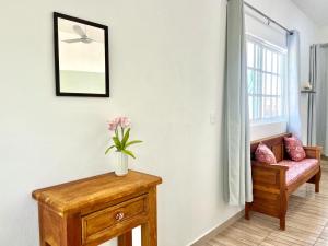 a room with a bench and a vase of flowers on a table at Perfect Place Cozumel - DIANA in Cozumel