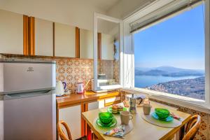 a kitchen with a table and a large window at Nicoletta's Lake View Stresa - Happy Rentals in Stresa