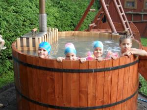 three little girls in a wooden barrel pool at Nagy Lak II. in Sub Cetate