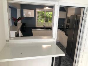 a kitchen with a white counter and a window at Villa Serenity in Saint-François +35 photos